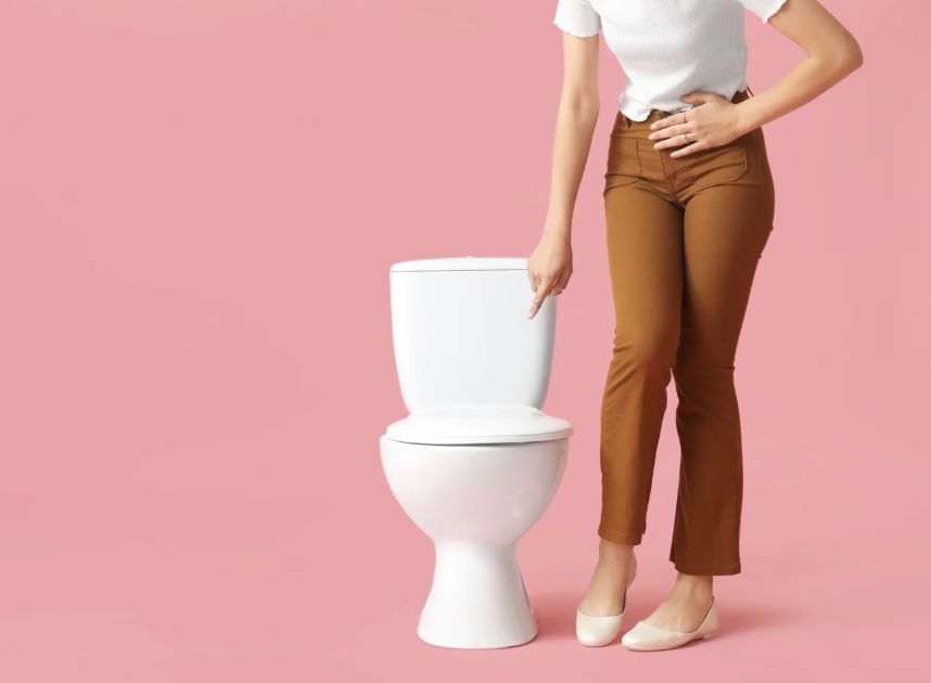 Femme assise, mains posées sur le bas-ventre, symbolisant l’inconfort urinaire lié à la cystite. Illustration du lien entre microbiote intestinal, vaginal et infections urinaires récidivantes.